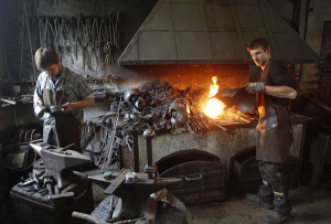 Blacksmith brothers Johann (R) and Georg Schmidberger work on ...