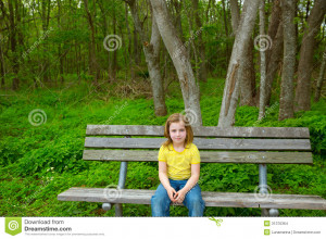 ... lonely children girl happy sitting on park bench on forest jungle