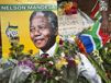 Flowers, posters, and messages left by mourners lie in front of Nelson ...