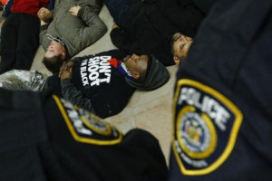 York Police Department officers watch demonstrators as they lie down ...