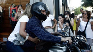 ... leaves the Greek finance ministry on his motorcycle with his wife