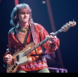 Brian May in Queen's good period, wearing one of his semi-capes