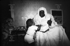 ... Idi Amin Dada smiles at his son as he reads the Quran t1 Idi Amin Dada