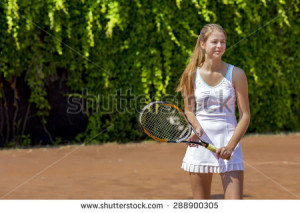 Smiling tennis athlete on play-field.Junior female stays on clay ...