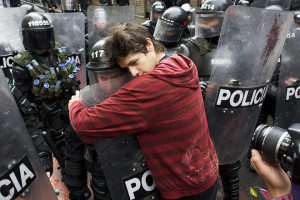 Bogotá, Colombia: A demonstrator embraces a riot police officer ...
