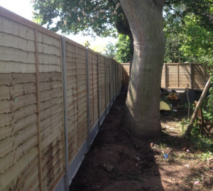 Concrete post and panel wooden fence