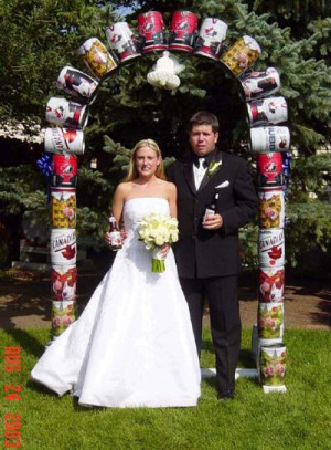 Ein Ehepaar steht unter einem Tor aus Bierfässern.