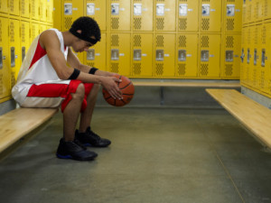 Sad basketball player in locker room after being cut