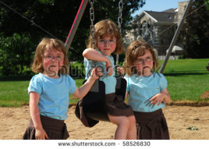 stock photo : Sisters swinging on the swingset