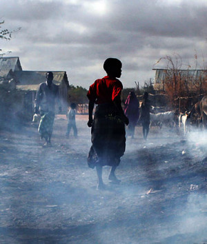 People walk through burning refuse in Dadaab, the worlds biggest ...