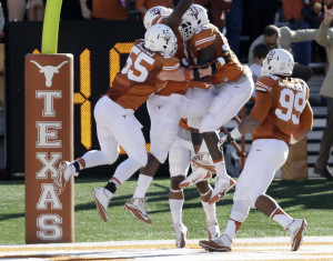 Texas' Chris Whaley (96) celebrates with teammates after he returned a ...