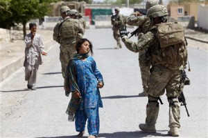 An Afghan girl walks past a U.S soldier from 4-73 Cavalry Regiment ...