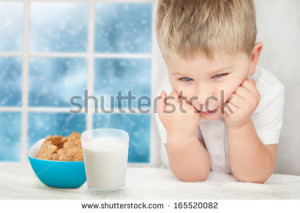 Sad little boy with glass of milk and cookies. Lack of appetite ...