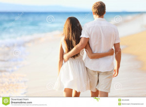 Vacation couple walking on beach together in love holding around each ...