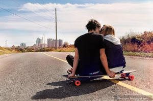 Kissing couple on skate board road young love