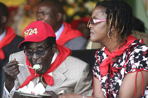 Zimbabwe’s President Robert Mugabe eats cake next to his wife Grace ...