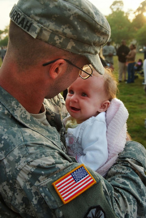 Army Spc. Adam Darrah holds his daughter Sept. 6, 2007, after ...
