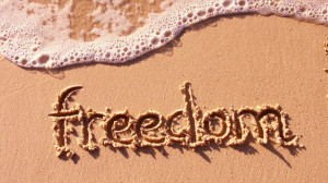 Zee en strand wallpaper met de tekst freedom in het zand geschreven ...