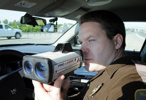 North Dakota State Trooper Jamey Jahner uses a laser speed gun along ...