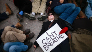 justice for Eric Garner, holds a placard while staging a protest ...