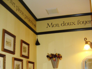 french wall quote in the toilet room with picture frames on the left ...