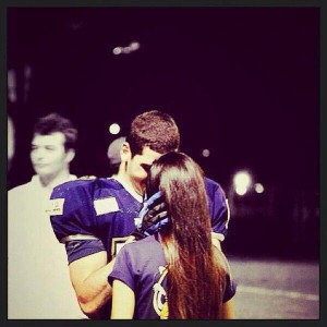 Football player kissing his girlfriend. 