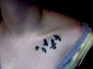 bold freehand little bird silhouettes tattooed on a collar bone