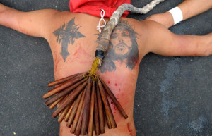flagellant whips his back with bamboo during the re-enactment of the ...