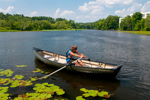 four people fishing on a lake in a rowboat