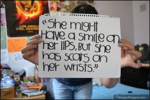 She might have a smile on her lips but she has scars on her wrists
