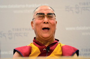 The Dalai Lama speaks during a press conference while supporters of ...