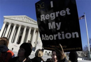 An anti-abortion protestor holds a sign in front of the US Supreme ...
