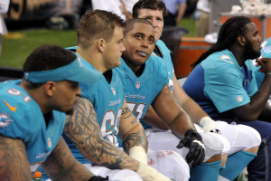 Incognito (68) and tackle Jonathan Martin (71) look up from the bench ...