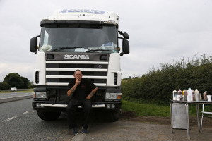 53 year-old lorry driver poses for a photograph in front of his truck ...