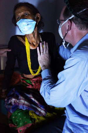 By flashlight during a power outage, Dr. Paul Farmer examines a 45 ...