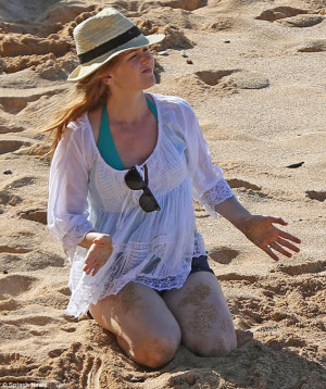 Isla Fisher displays her lean legs whilst frolicking on the beach with ...