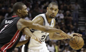 San Antonio Spurs' Tim Duncan (21) drives past Miami Heat's Chris Bosh ...