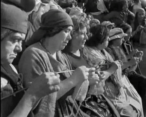 Film still of women knitting while watching the beheadings of the ...