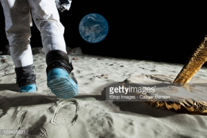Stock Photo : An astronaut walking on the moon, rear view, low section