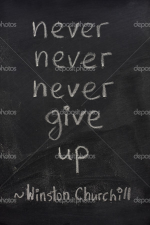 Never give up phrase on blackboard - Stock Image