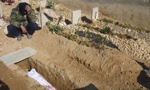 Free Syrian Army fighter mourns near the grave of his comrade who ...