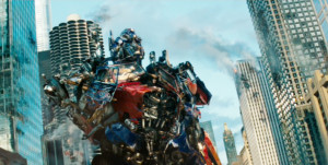 Pictured:One-armed, battle-scarred Optimus Prime stands in the ruins ...