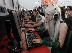 girl dressed in costume plays a video game at the PAX East gaming ...