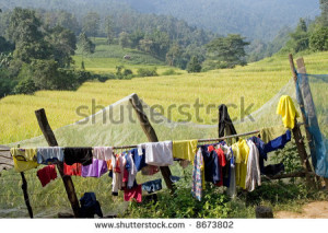clothes drying on the fence fields in the background. - stock photo ...