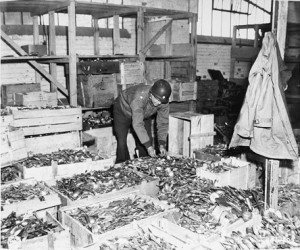 An American soldier sorts through crates of silverware taken from ...