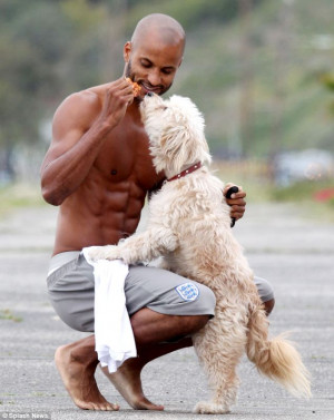 Feeding time: Whittles shows of his abs while giving the pooch a snack