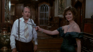 ... Scarlett ( Lesley Ann Warren ) holds the revolver on Col. Mustard