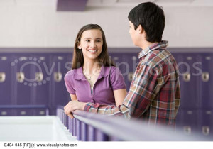Teenage boy and girl talking in a corridor