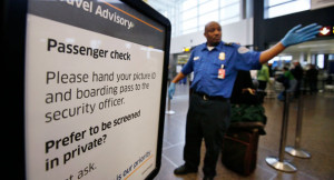 TSA officer waves passengers toward a security checkpoint in Seattle ...