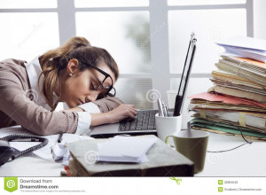 Tired businesswoman sleeping on the desk, in front of the computer ...